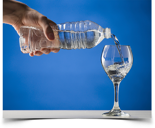 Pouring bottled alkaline water into a wine glass